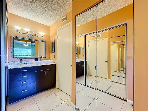 a bathroom with a glass door shower a sink and a mirror