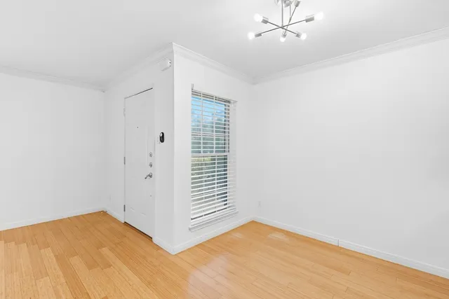 a view of a room with wooden floor and white walls