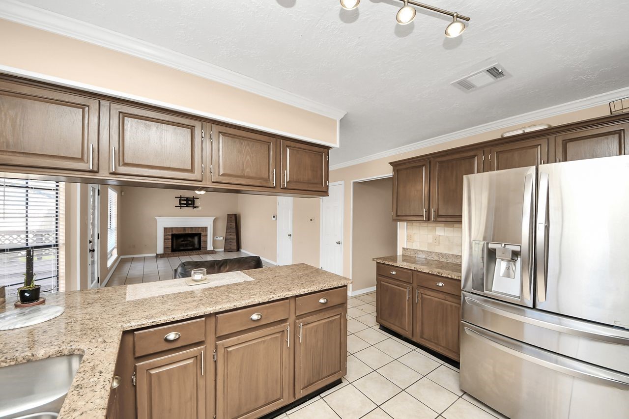 7607 Plum Tree Forest Circle Houston, TX 77095 - Photo 17 of 42 a kitchen with granite countertop a sink stainless steel appliances and cabinets