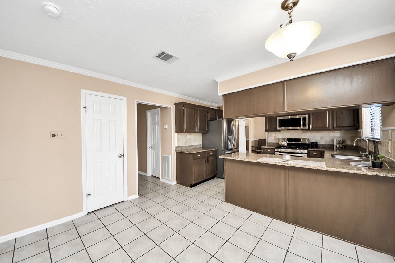 7607 Plum Tree Forest Circle Houston, TX 77095 - Photo 19 of 42 a large kitchen with a large counter top stainless steel appliances and cabinets