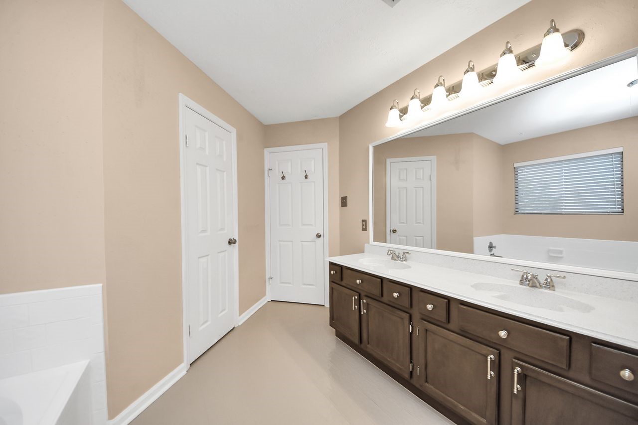 7607 Plum Tree Forest Circle Houston, TX 77095 - Photo 25 of 42 a spacious bathroom with a double vanity sink and a mirror