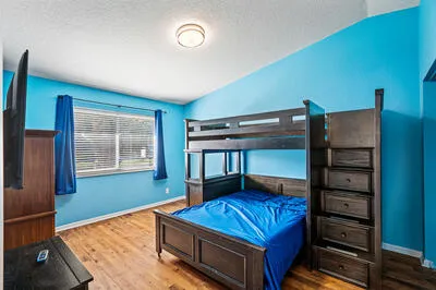 a bedroom with a bed a dresser and window