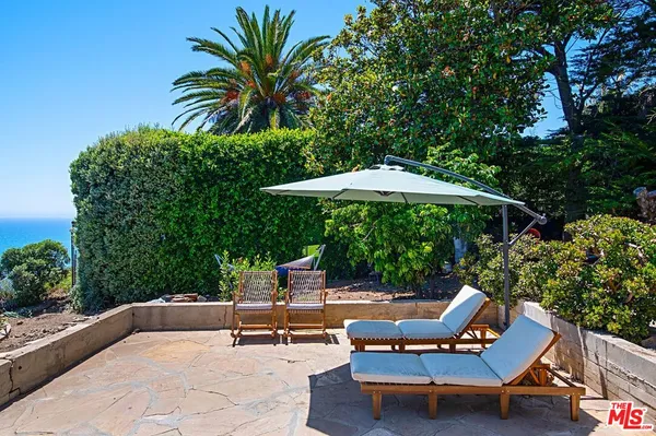 a view of a patio with table and chairs with wooden floor and fence