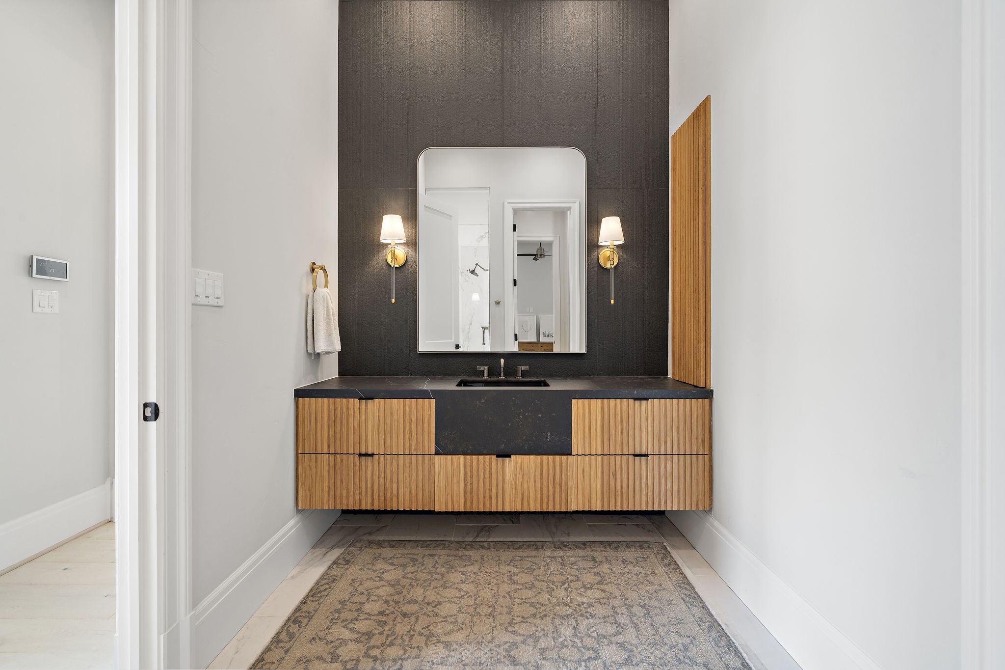 5511 Fulbrook Road Fulshear, TX 77441 - Photo 23 of 50 This is the 2nd bathroom in the primary suite designed with a black focal wall, wood trim cabinetry, and floating vanity. It too has a private lavatory and dedicated entry to the walk-in shower.