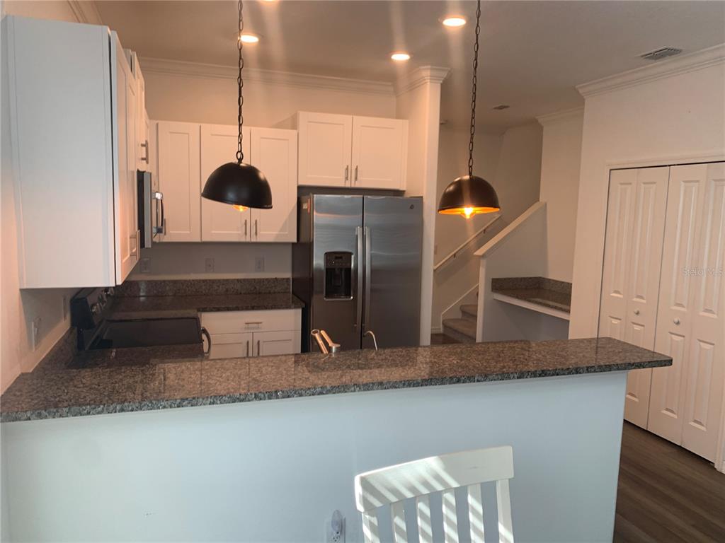 6930 Ripple Pond Loop Zephyrhills, FL 33541 - Photo 11 of 29 a kitchen with stainless steel appliances granite countertop a sink and a refrigerator