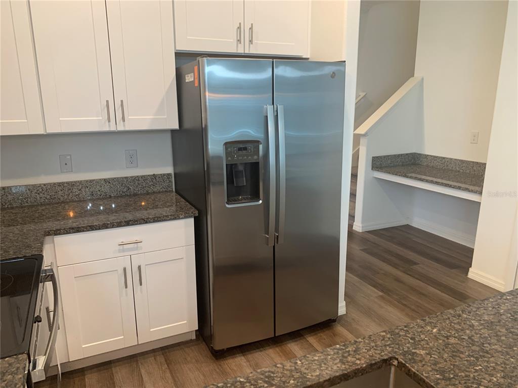 6930 Ripple Pond Loop Zephyrhills, FL 33541 - Photo 12 of 29 a kitchen with a refrigerator and cabinets