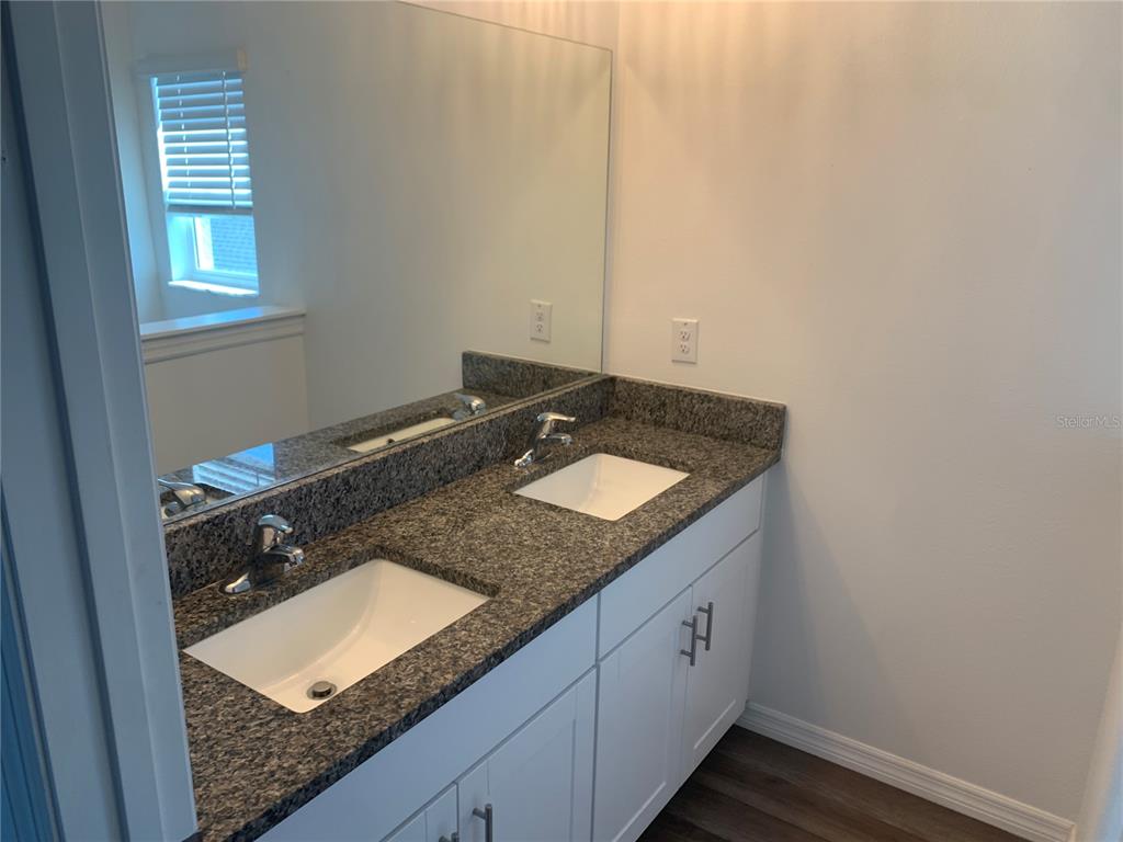 6930 Ripple Pond Loop Zephyrhills, FL 33541 - Photo 20 of 29 a bathroom with a granite countertop sink and a mirror
