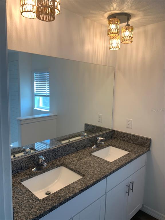 6930 Ripple Pond Loop Zephyrhills, FL 33541 - Photo 21 of 29 a bathroom with a granite countertop sink a mirror and a window