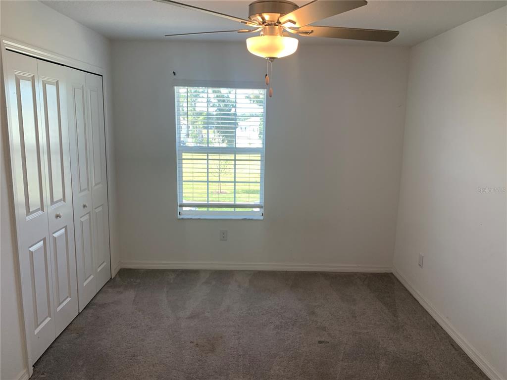 6930 Ripple Pond Loop Zephyrhills, FL 33541 - Photo 25 of 29 an empty room with windows and chandelier fan