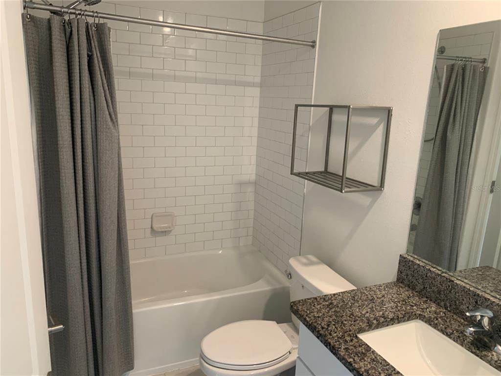 6930 Ripple Pond Loop Zephyrhills, FL 33541 - Photo 26 of 29 a bathroom with a granite countertop toilet sink and shower