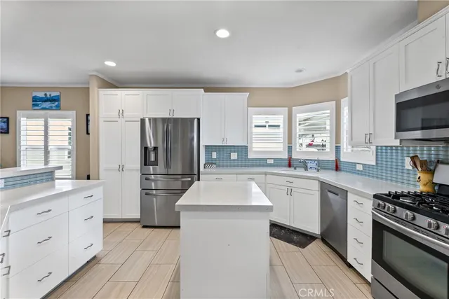 a kitchen with white cabinets and stainless steel appliances