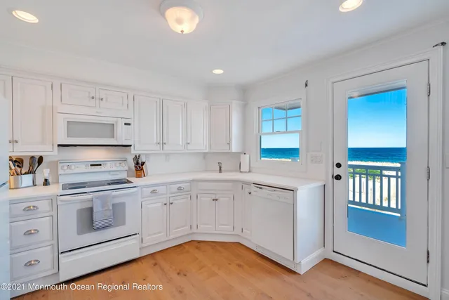 a living room with furniture a flat screen tv and kitchen view