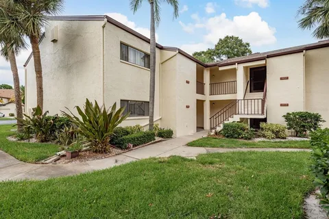 a front view of a house with a yard and potted plants