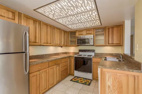 a view of a kitchen with refrigerator and mirror
