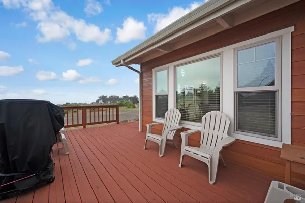 a balcony with wooden floor table and chairs