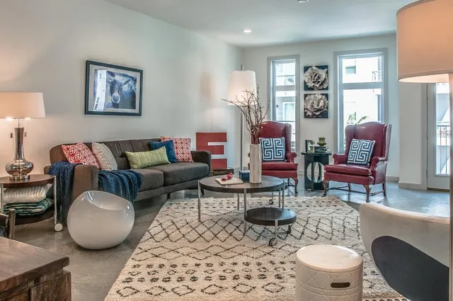 a living room with furniture a rug and wall painting