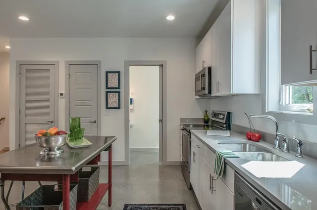 a open kitchen with stainless steel appliances granite countertop a sink stove and refrigerator