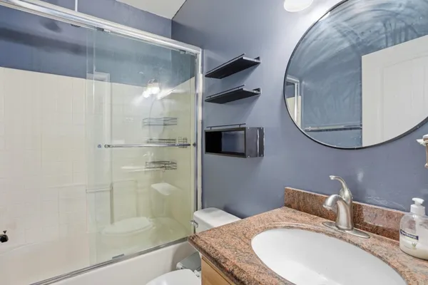 a bathroom with a granite countertop sink mirror and shower