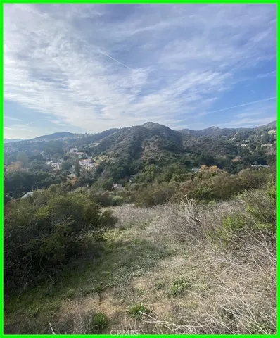 a view of a dry yard with mountains in the background