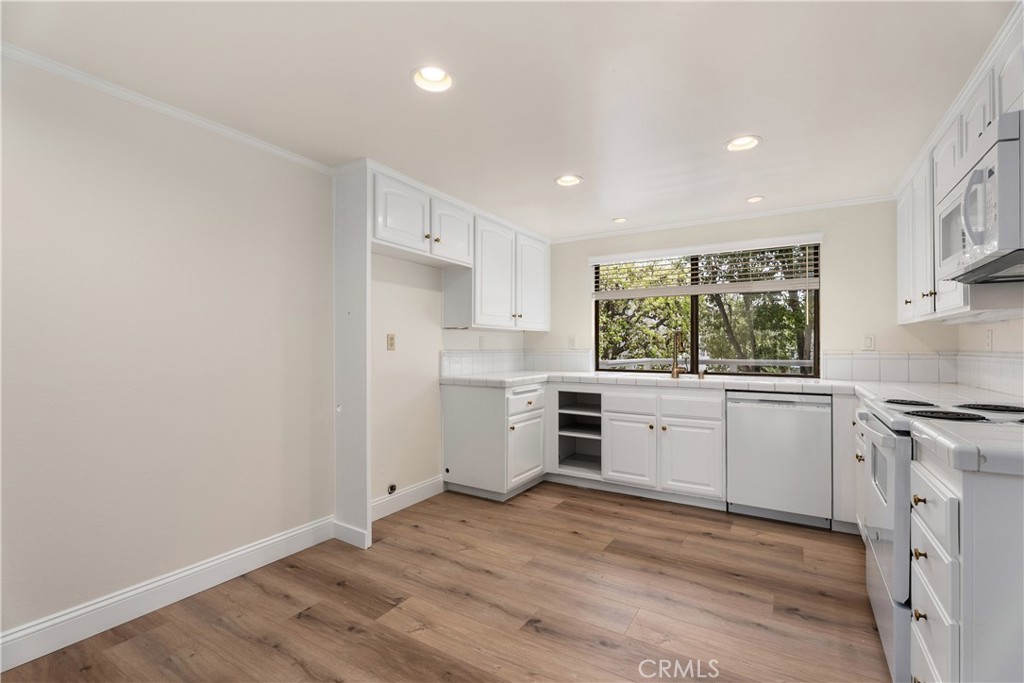 3 Kamalii Court, Unit 276 Newport Beach, CA 92663 - Photo 11 of 28 a kitchen with a white stove top oven and white cabinets