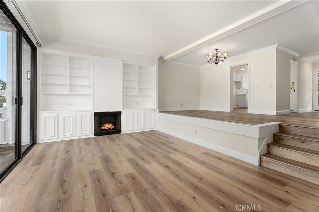 3 Kamalii Court, Unit 276 Newport Beach, CA 92663 - Photo 5 of 28 a view of an empty room with wooden floor and a fireplace