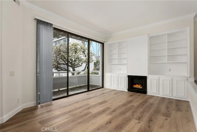 a view of a room with wooden floor and a ceiling fan