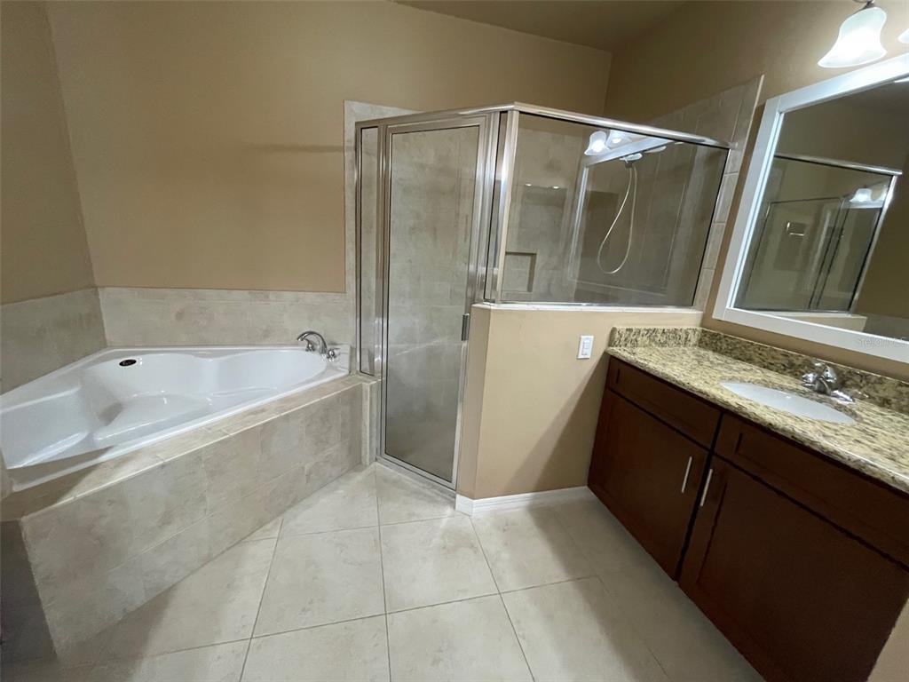 7879 Southwest 80th Drive Gainesville, FL 32608 - Photo 12 of 23 a bathroom with a granite countertop sink a mirror and a bathtub
