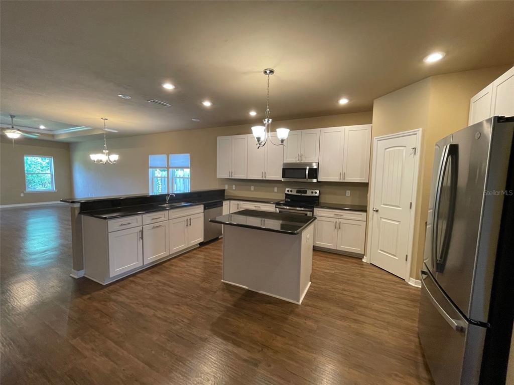 7879 Southwest 80th Drive Gainesville, FL 32608 - Photo 3 of 23 a large kitchen with a refrigerator a stove top oven and a sink