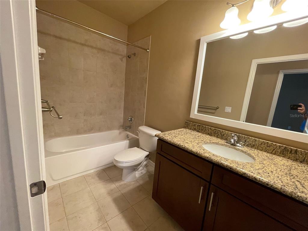 7879 Southwest 80th Drive Gainesville, FL 32608 - Photo 6 of 23 a bathroom with a granite countertop sink toilet mirror and bathtub