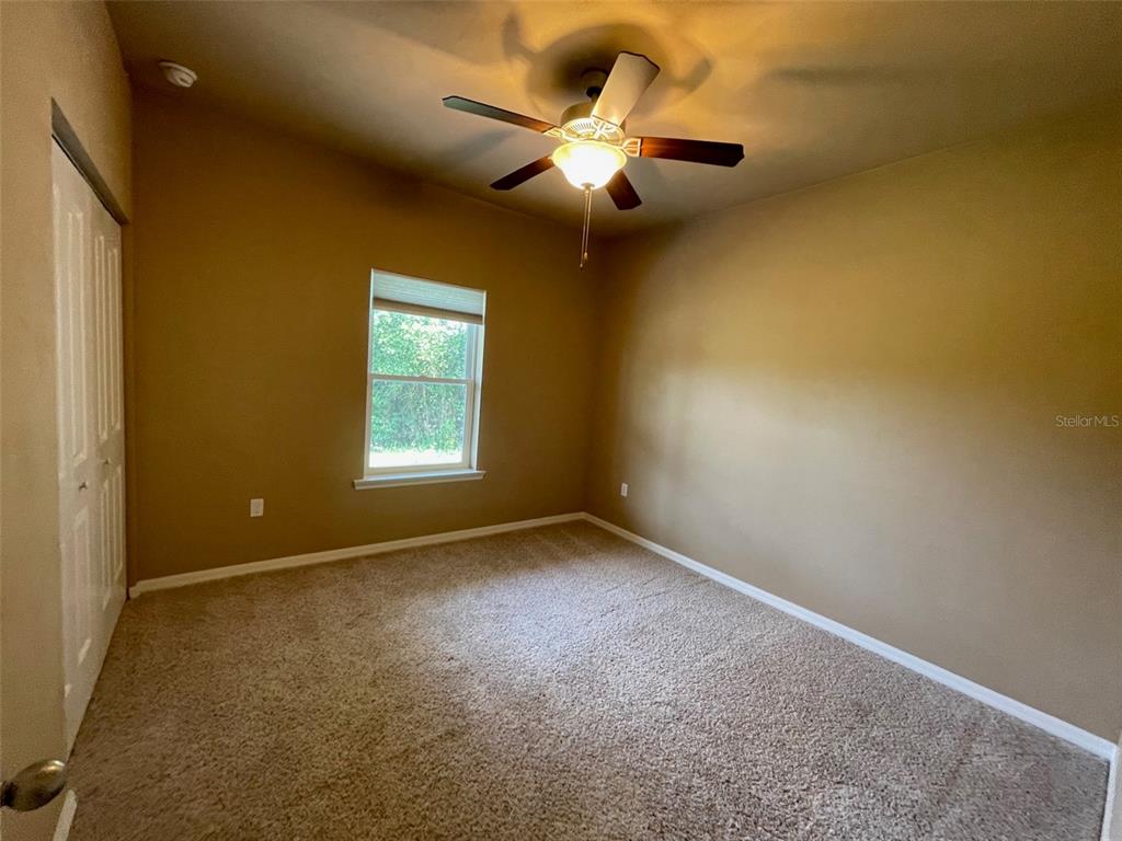 7879 Southwest 80th Drive Gainesville, FL 32608 - Photo 7 of 23 an empty room with a ceiling fan and window