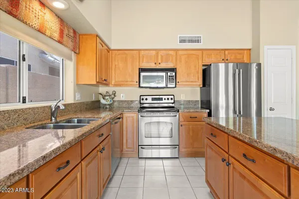 a kitchen with stainless steel appliances granite countertop a sink stove and refrigerator