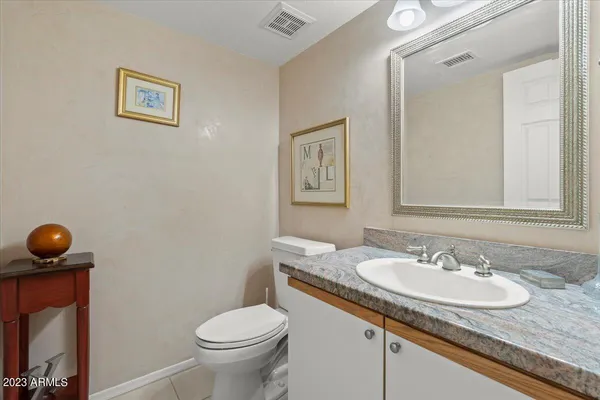 a bathroom with a granite countertop sink and a toilet