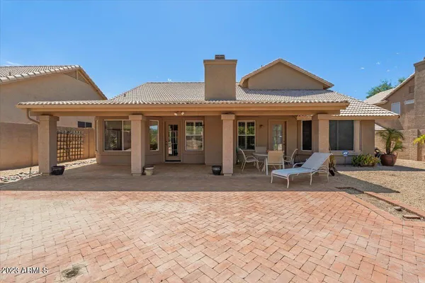 a view of a house with table and chairs in patio