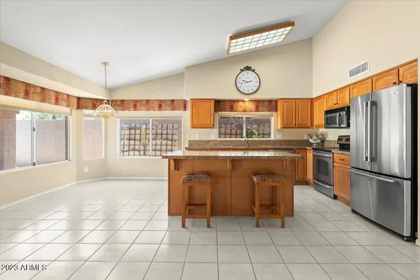 a kitchen with stainless steel appliances granite countertop a stove a sink and a refrigerator