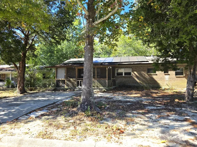 a front view of a house with yard tree and wooden fence
