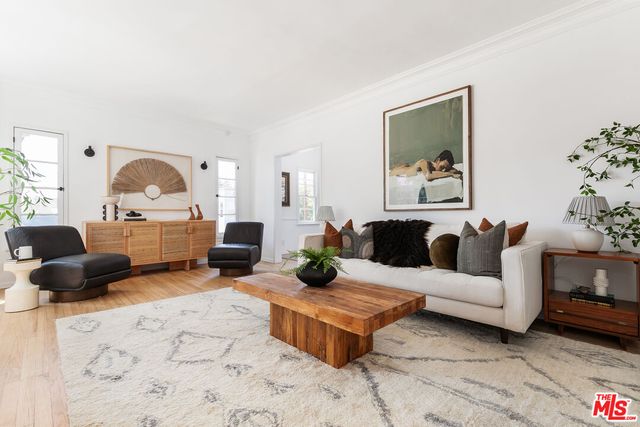 a living room with furniture a rug and a large mirror