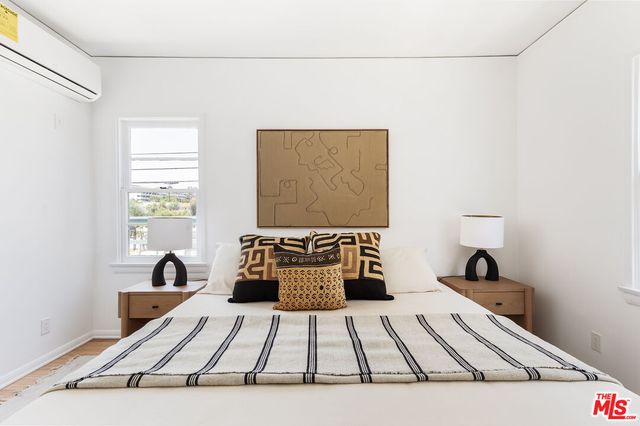 a view of a bedroom with a bed and a window