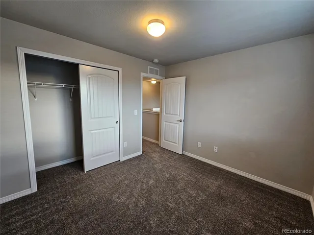 an empty room with closet and a bathroom