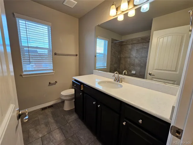 a bathroom with a double vanity sink a toilet and a mirror