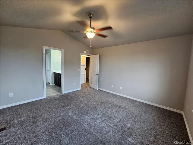 an empty room with closet and a chandelier fan