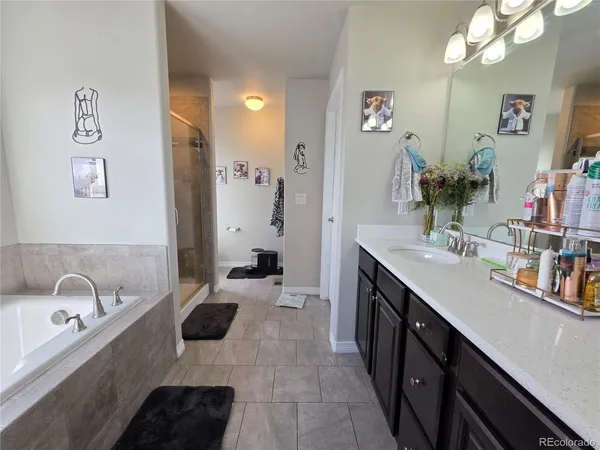 a spacious bathroom with a tub sink double vanity and mirror