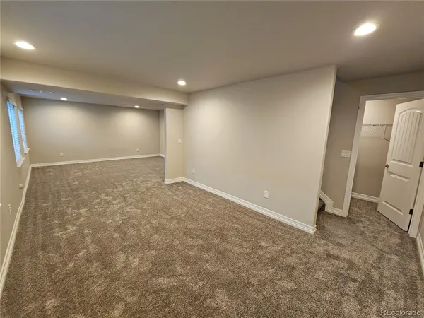 an empty room with a wooden door and a glass door