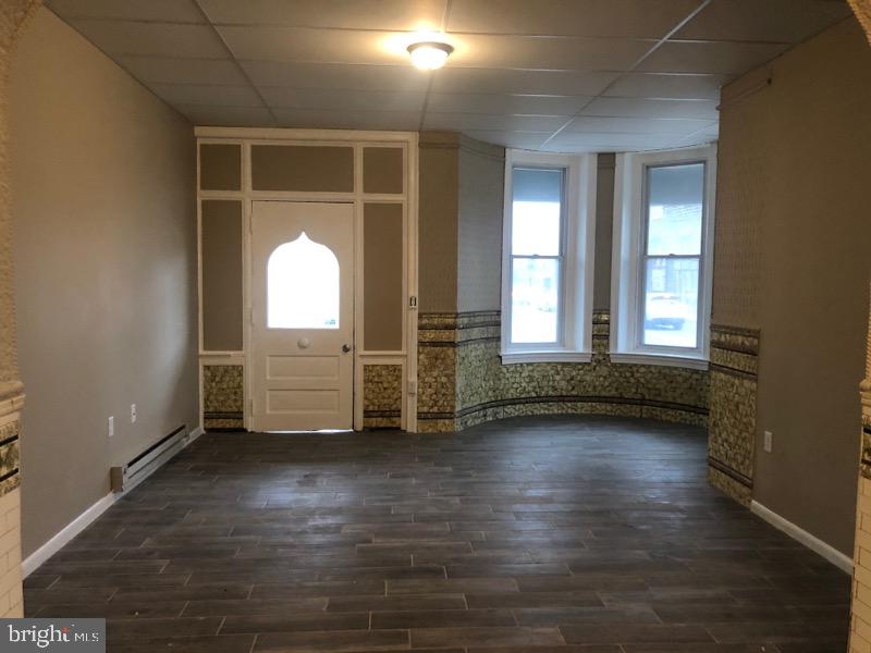 101 East Broad Street, Unit 2 Quakertown, PA 18951 - Photo 2 of 8 an empty room with wooden floor and windows