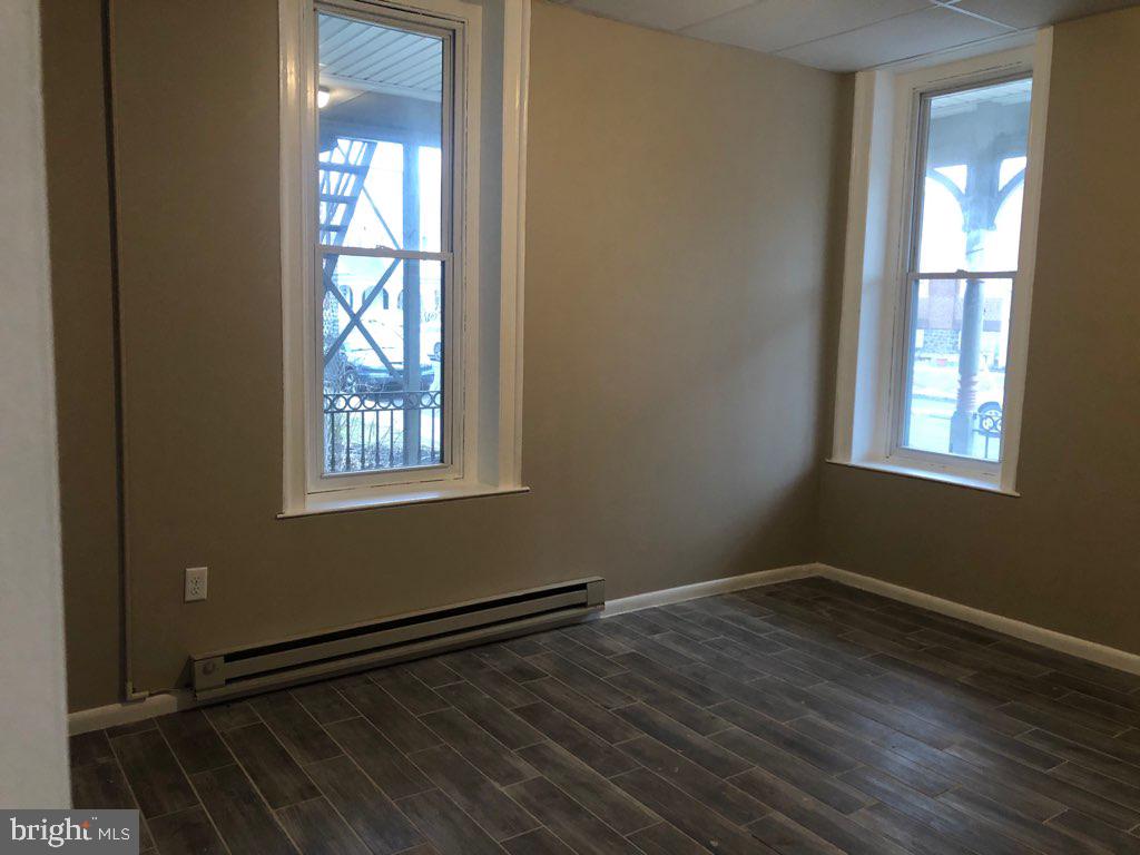 101 East Broad Street, Unit 2 Quakertown, PA 18951 - Photo 7 of 8 a view of an empty room with wooden floor and a window