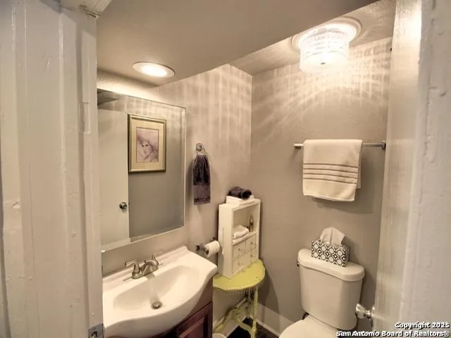 a bathroom with a sink mirror and toilet