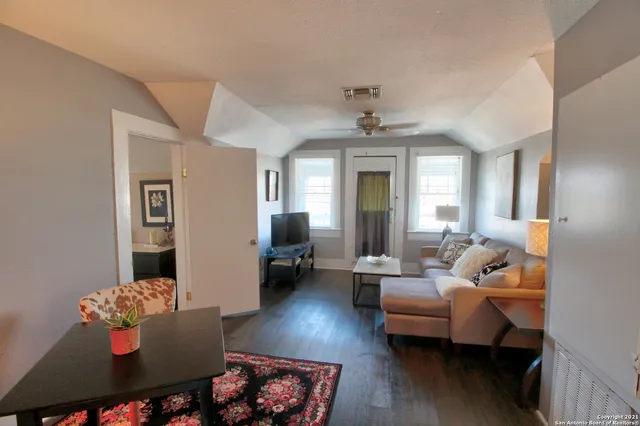 a living room with furniture and wooden floor