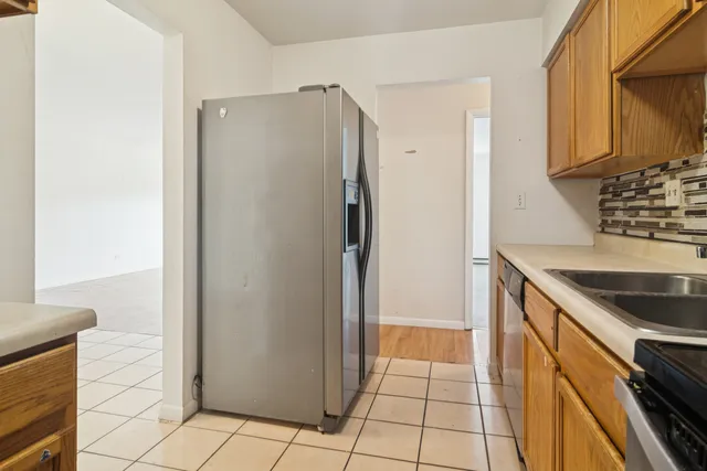 a kitchen with a refrigerator and a stove top oven