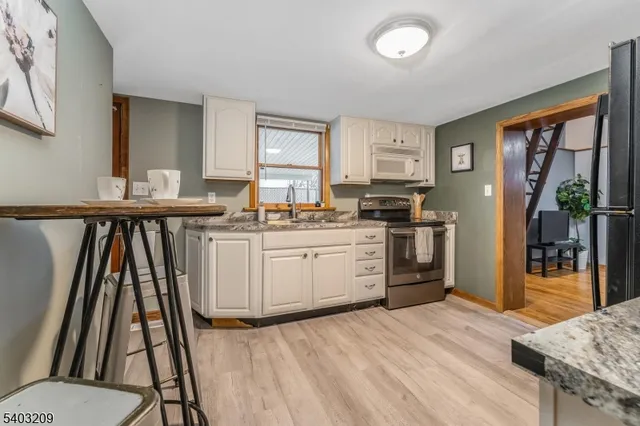 a kitchen with wooden floor and white appliances