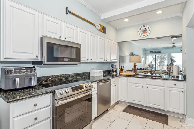 a kitchen with granite countertop a stove sink and cabinets