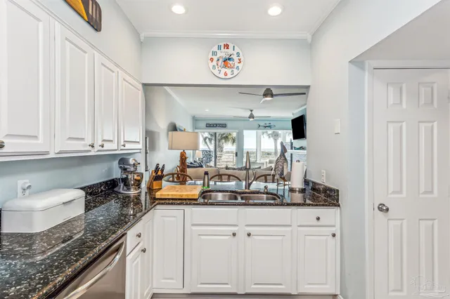 a kitchen with stainless steel appliances granite countertop a sink and a white cabinets